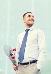 Poster - young smiling businessman with skateboard outdoors