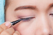© pingpao - Makeup concept, Closeup asian woman applying eyeliner on eye