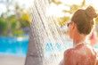 © el.rudakova - young woman refreshing in shower near pool