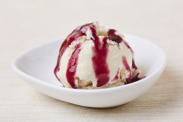 Wall Mural - A scoop of fresh vanilla ice cream with home-made cherry sauce