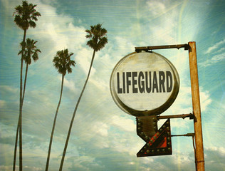 Wall Mural - aged and worn vintage photo of lifeguard sign with palm trees