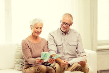 Canvas Print - senior couple with money and calculator at home