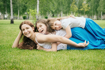 Wall Mural - Mother with children having fun playing outdoors