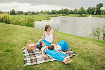 Wall Mural - Mother with young daughters having picnic