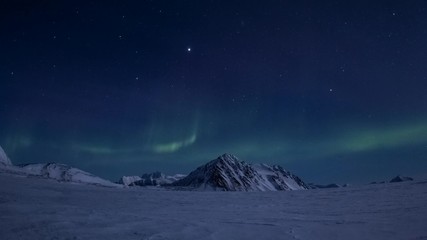 winter in arctic. starry sky in the polar night. northern lights over glacier.