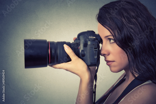 Obraz w ramie Side profile young woman taking pictures with professional camera