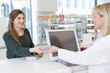© Westend61 - Portrait of female customer paying cashless in a pharmacy
