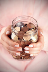 Poster - Woman holding money jar with coins close up