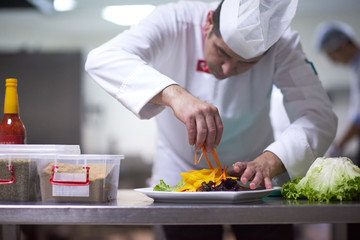 Canvas Print - chef in hotel kitchen preparing and decorating food