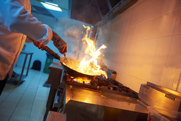 Wall Mural - chef in hotel kitchen prepare food with fire