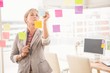 © WavebreakmediaMicro - Casual businesswoman writing on sticky notes