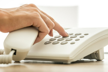 Wall Mural - Closeup view of female secretary dialing a telephone number on w