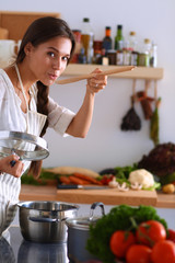 Wall Mural - Cooking woman in kitchen with wooden spoon