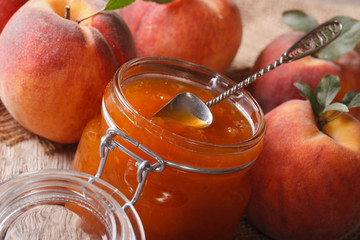 Wall Mural - Peach jam in a glass jar close up on the table. Horizontal
