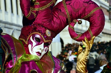 Masquerade in violet at the Carnival of Venice, St. Mark's square on the background