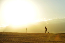 Profile Silhouette Of Young Man Running In Countryside Training Cross Country Jogging Discipline In Summer Sunset On Beautiful Rural Landscape