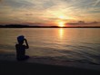 child looking at bright sunset over lake
