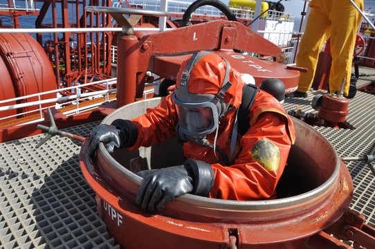 Fototapete - man in chemical suit entering inside cargo tank on deck of chemical tanker for cleaning operation