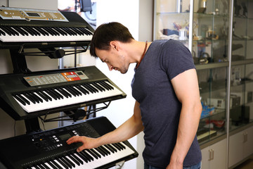 Wall Mural - Handsome young man in music store