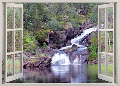 Fototapeta na wymiar Open window view to mountain waterfall and pond