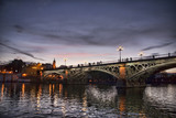 Fototapeta Paryż - hermoso atardecer del puente de Triana visto desde Sevilla, España