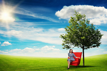 Wall Mural - young woman resting in red chair