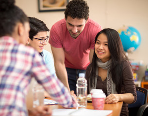 Asian student studying with colleagues in classroom