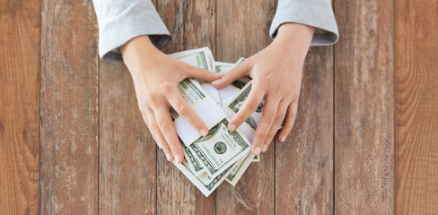 Poster - close up of woman hands counting us dollar money