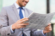 © Syda Productions - close up of smiling businessman reading newspaper