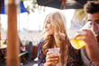 © Joshua Resnick - woman with her boyfriend enjoying drinking a beer at outdoor beach side bar or pub