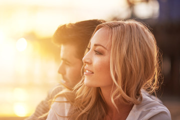 romantic couple cuddling on beach at sunset