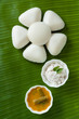 Indian idly served as a flower - Fresh steamed Indian Idly (Idli / rice cake) arranged decoratively as a flower on traditional banana leaf. Served with coconut chutney and sambar. Natural light used.