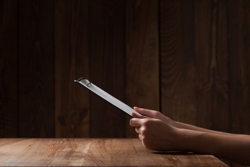 Wall Mural -  woman's hand holding paper over wooden table