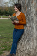 Beautiful young woman with reading a book on tree background