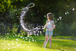 © MNStudio - Adorable little girl playing with a garden hose