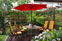 Wooden Furniture With Umbrella In Backyard Patio.