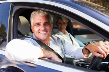 middle aged couple driving a car