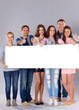 © shefkate - Young group of people standing together, holding a blank and