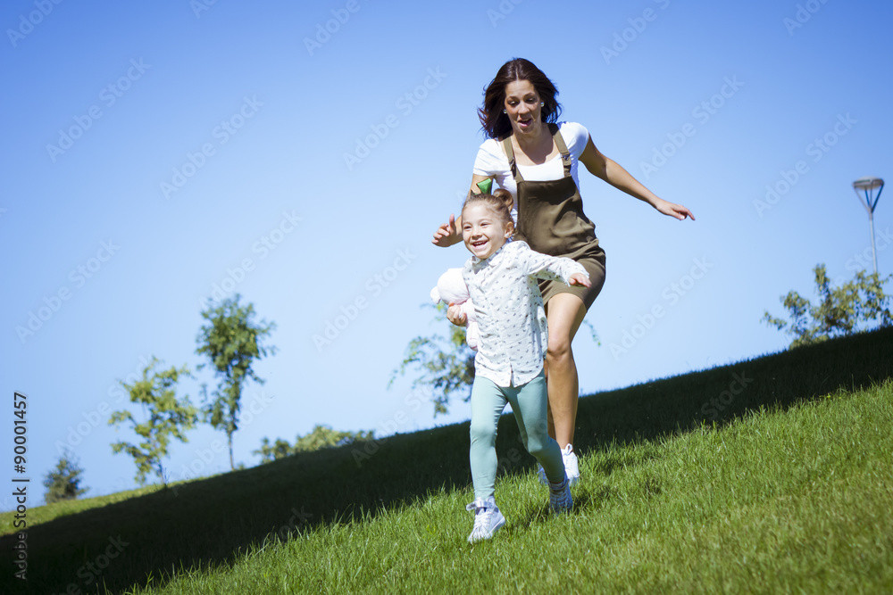 Foto stock di Una niña y su mama corriendo por el parque. Madre e hija ...