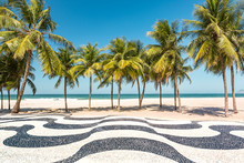 Palm Trees And The Iconic Copacabana Beach Mosaic Sidewalk, In Rio De Janeiro, Brazil.