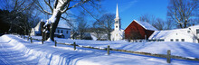 This Town Was Settled In 1776. It Is A Typical Image Of New England In The Winter. There Is A White Church With Tall Steeple, Snow Covered Trees, A Wooden Fence In The Foreground Behind A Snow Covered Road. There Is Also A Red Barn Or Building Next To The Church.