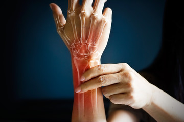 acute pain in a woman wrist, colored in red on dark blue background
