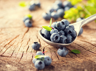 Sticker - Blueberry in spoon on cracked wooden background. Ripe and juicy fresh berries