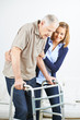 Krankenpfleger hilft Senior beim Gehen