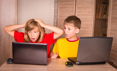 girl having a computer problem. cute children using laptops.