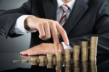 Businessman's Fingers Walking On Coins