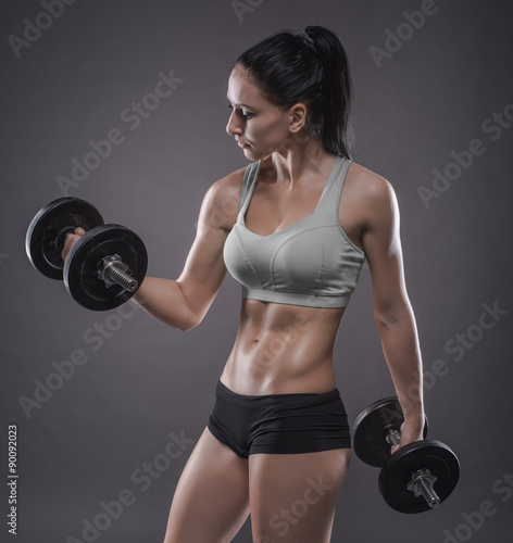 Nowoczesny obraz na płótnie athletic young woman doing a fitness workout with dumbbells on g