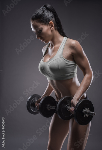 Fototapeta na wymiar athletic young woman doing a fitness workout with dumbbells on g