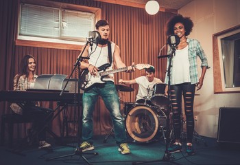 Wall Mural - Multiracial music band performing in a recording studio