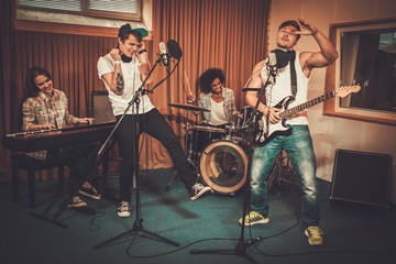 Wall Mural - Multiracial music band performing in a recording studio